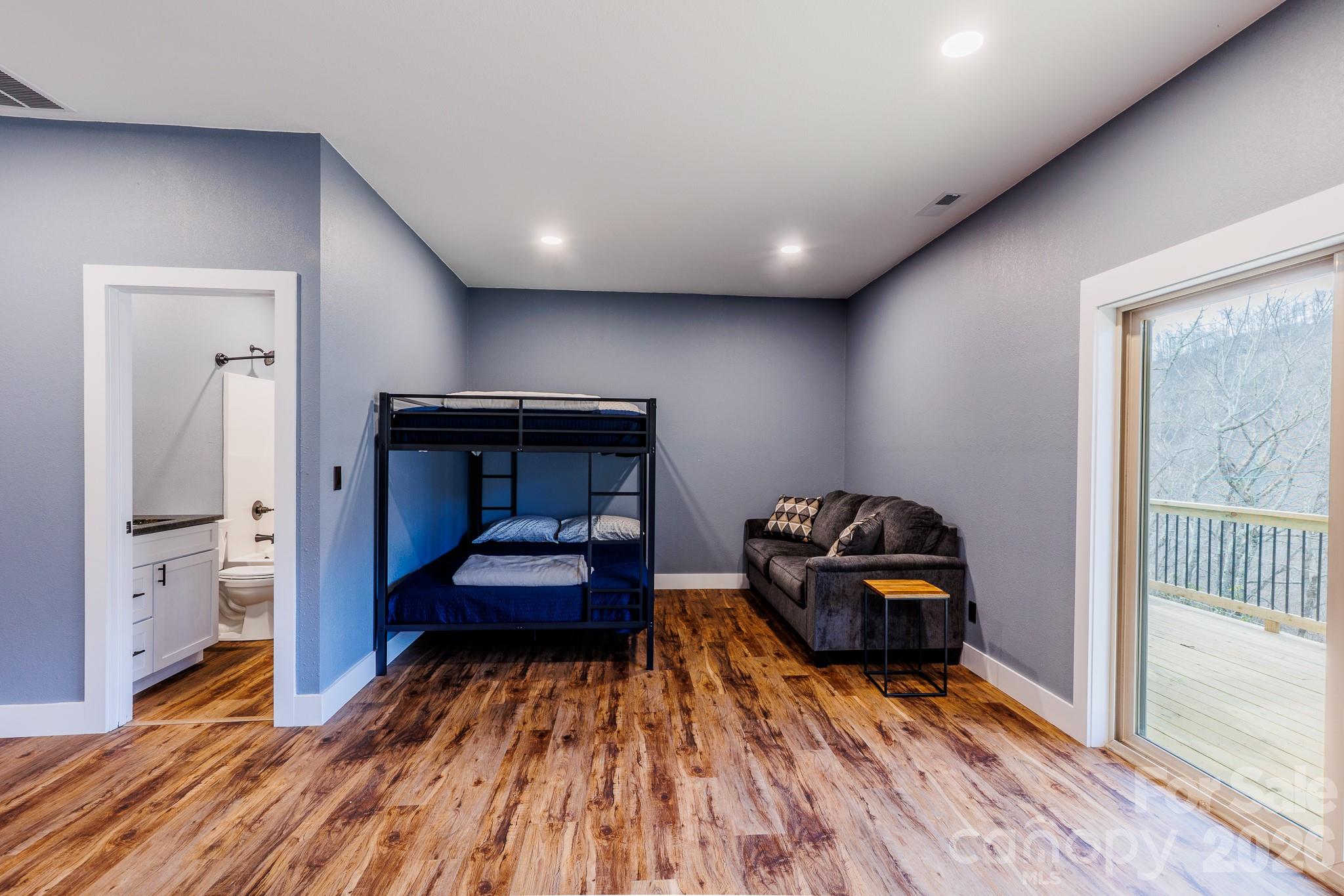 601 Tater Patch Road Maggie Valley, NC 28751 - Photo 25 of 32 a bedroom with furniture and a wooden floor