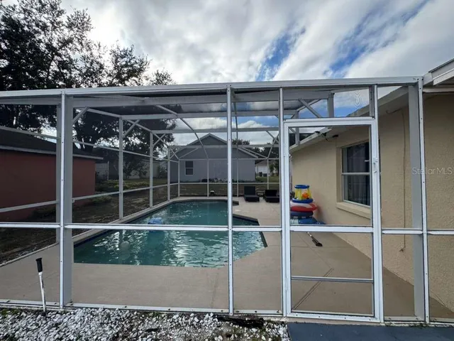 a view of a door with wooden floors and couches