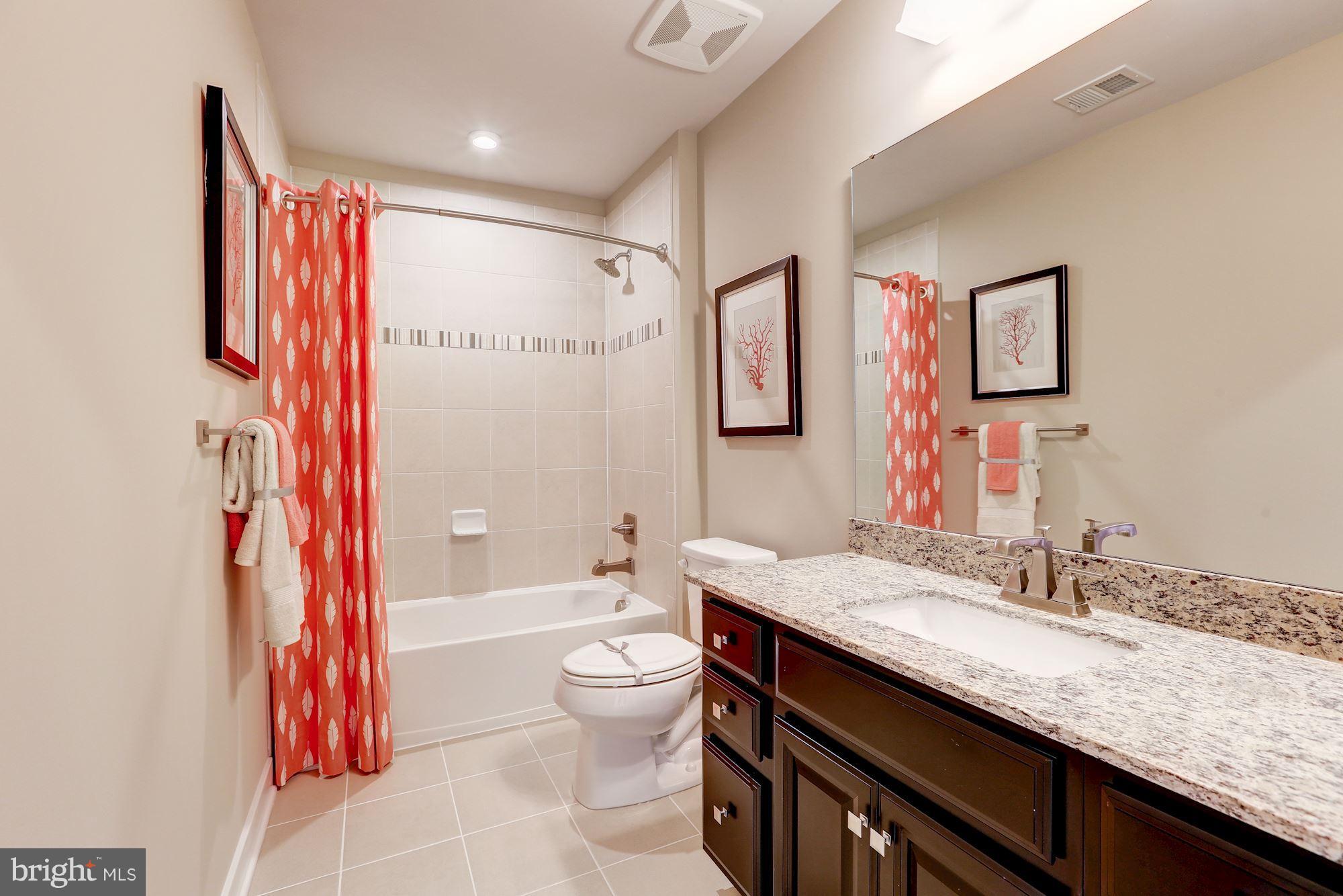 7641 Deepnotch Way Hanover, MD 21076 - Photo 13 of 25 a bathroom with a granite countertop sink a toilet a shower curtain and a large mirror