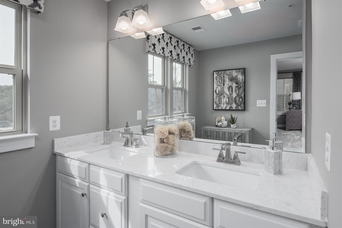 7641 Deepnotch Way Hanover, MD 21076 - Photo 14 of 25 a bathroom with double vanity sinks a vanity and a large mirror