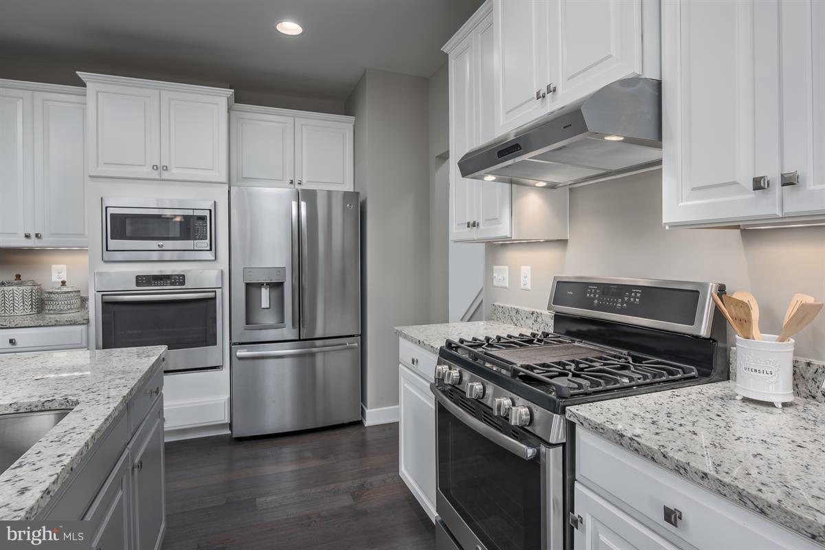 7641 Deepnotch Way Hanover, MD 21076 - Photo 2 of 25 a kitchen with granite countertop stainless steel appliances and white cabinets