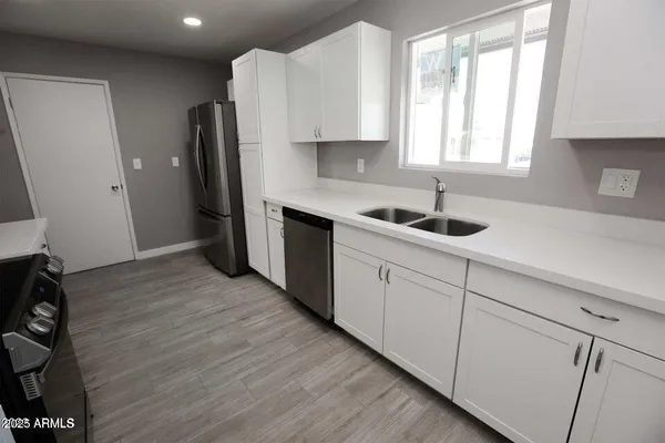 a kitchen with stainless steel appliances granite countertop a sink stove and refrigerator
