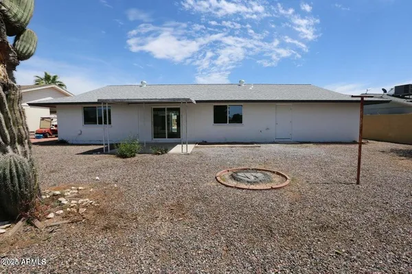 a backyard of a house with table and chairs