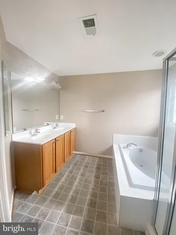 a bathroom with a tub sink and mirror