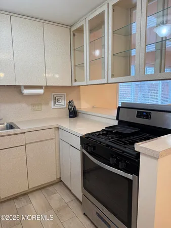 a kitchen with stainless steel appliances granite countertop white cabinets and a stove