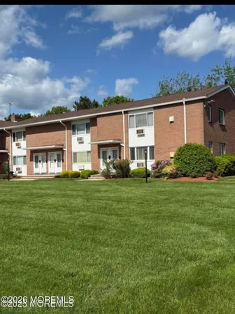 a view of a house with a big yard and large trees