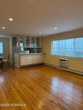 a large kitchen with stainless steel appliances wooden floor and a large window