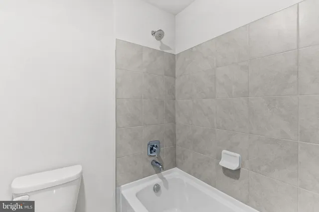 a bathroom with a toilet a sink a mirror and vanity