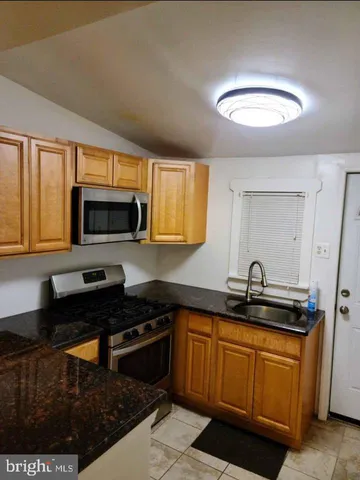 a kitchen with granite countertop a sink stainless steel appliances and cabinets