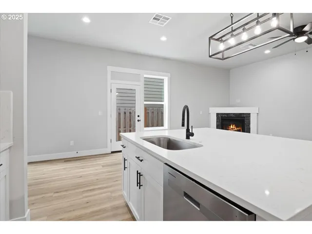 a kitchen with kitchen island white cabinets and stainless steel appliances