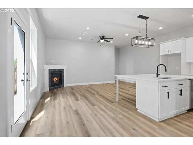 a room with a chandelier fan and a window