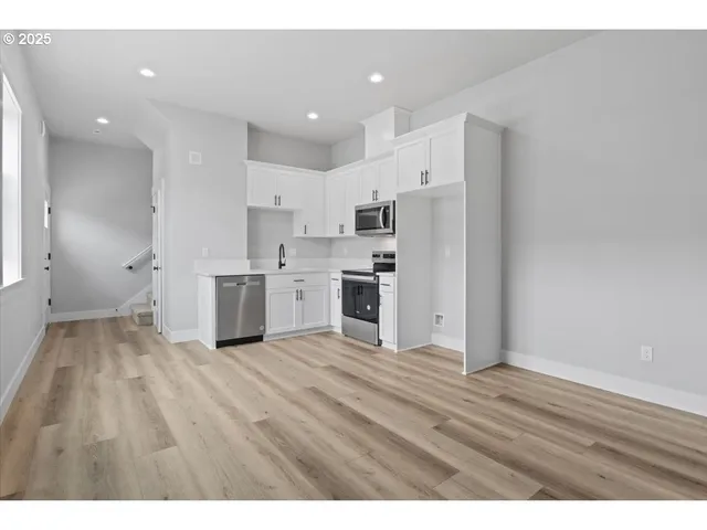 a kitchen with stainless steel appliances a sink a stove a microwave and cabinets