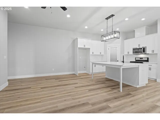 a kitchen with stainless steel appliances kitchen island a refrigerator sink and cabinets