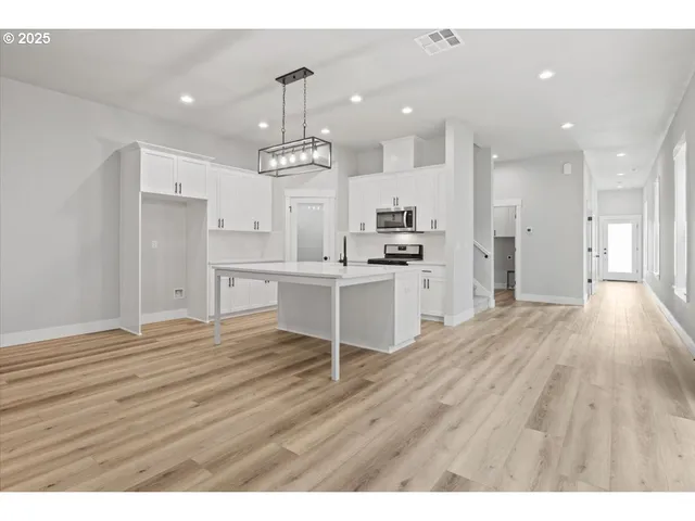 a view of a kitchen with wooden floor and a sink