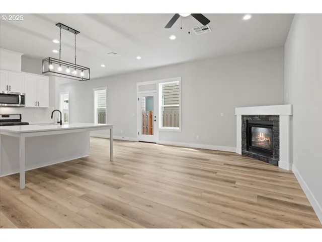a large kitchen with cabinets wooden floor and stainless steel appliances