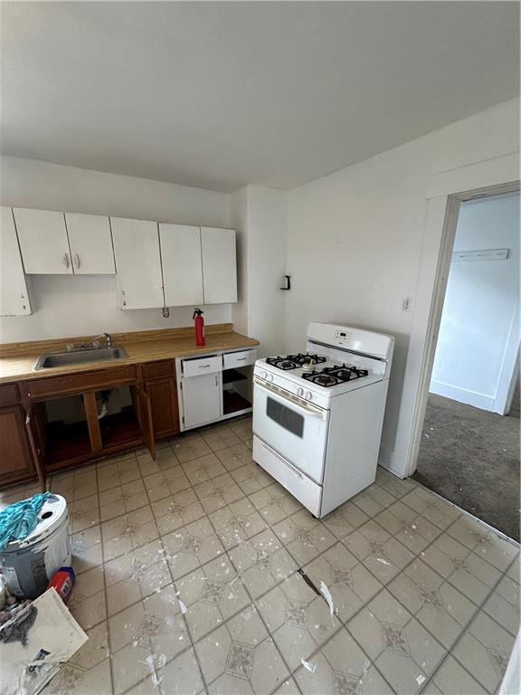 1131 12th Street McKees Rocks, PA 15136 - Photo 25 of 45 a kitchen with a stove and white cabinets