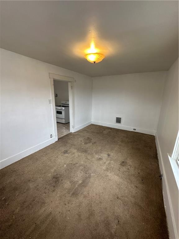 1131 12th Street McKees Rocks, PA 15136 - Photo 29 of 45 an empty room with a chandelier fan and a fireplace