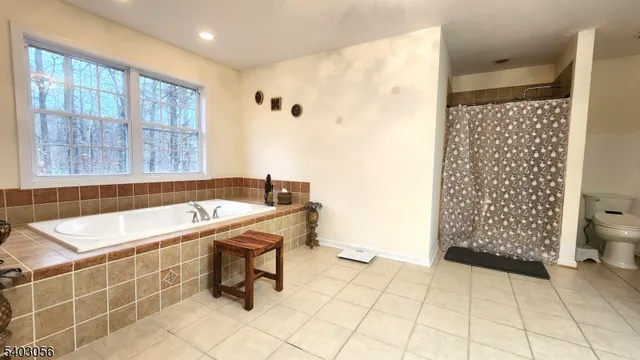 a bedroom with a bed and flat tv screen on the dresser