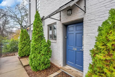 a kitchen with granite countertop a refrigerator and wooden floors
