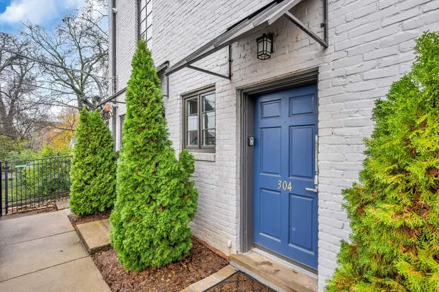 a kitchen with granite countertop a refrigerator and wooden floors