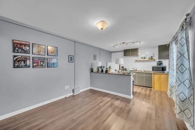 a room with stainless steel appliances wooden floors and view living room