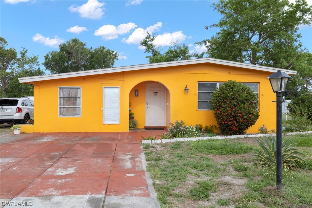 16 Massachusetts Road Lehigh Acres, FL 33936 - Photo 1 of 20 a front view of a house with garden