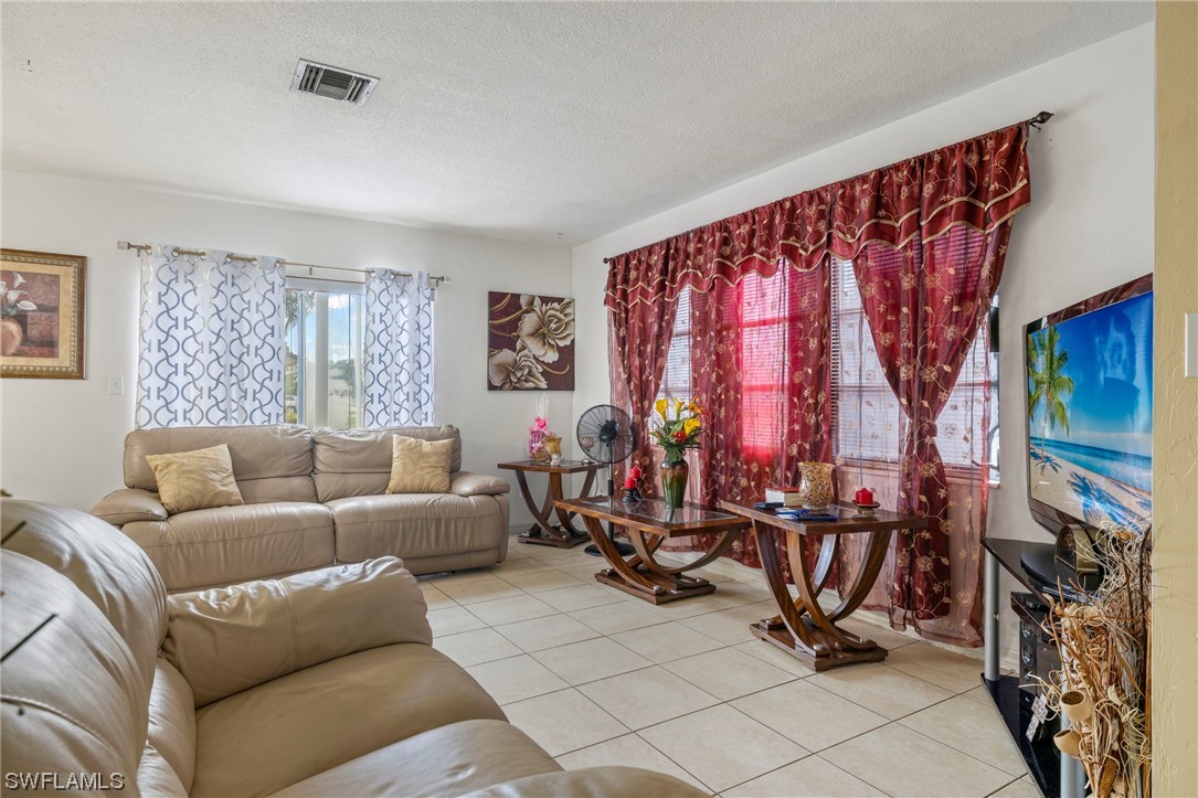 16 Massachusetts Road Lehigh Acres, FL 33936 - Photo 9 of 20 a living room with furniture a window and a flat screen tv
