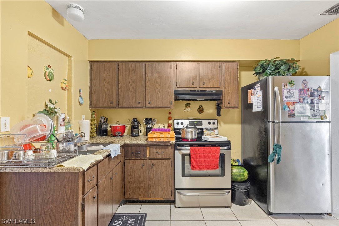 16 Massachusetts Road Lehigh Acres, FL 33936 - Photo 10 of 20 a kitchen with stainless steel appliances granite countertop a refrigerator sink and stove