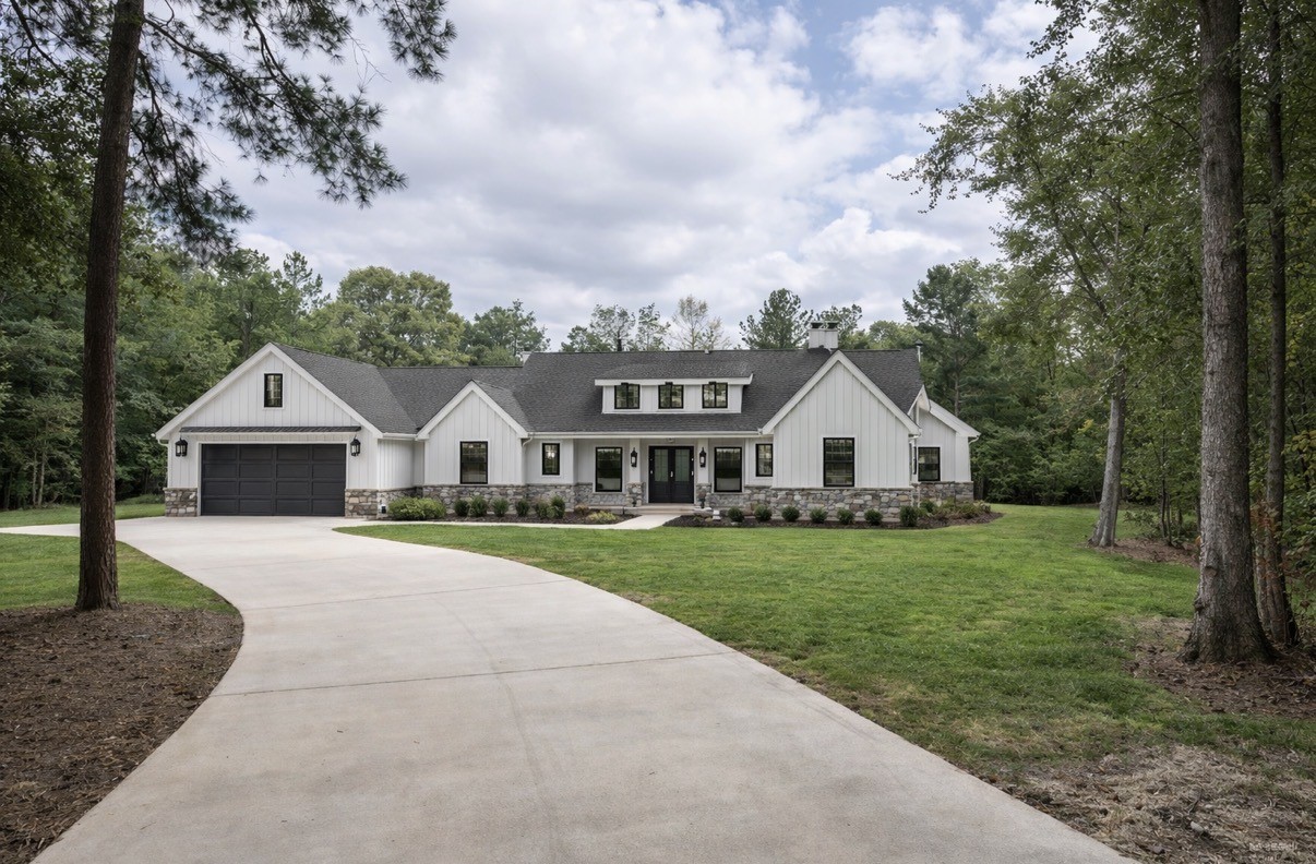 a front view of a house with a yard and trees