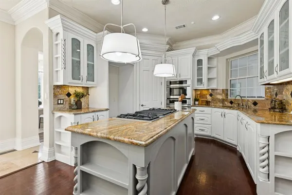 a kitchen with a stove a refrigerator a sink and chairs