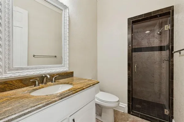 a bathroom with a granite countertop sink toilet and shower