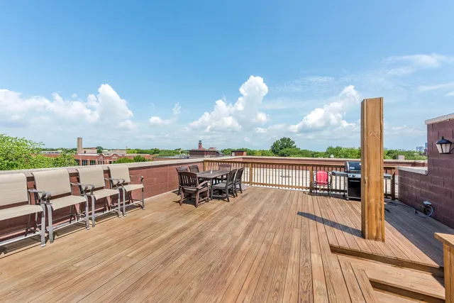 a view of a balcony with chairs and wooden floor