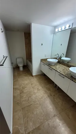 a spacious bathroom with a granite countertop sink and a mirror