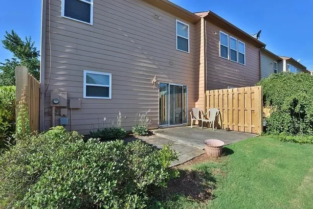 a view of a brick house with a yard and plants