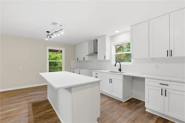 a kitchen with a sink cabinets and wooden floor
