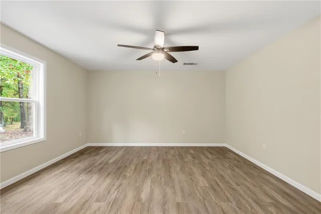 wooden floor in an empty room with a window