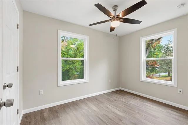 an empty room with wooden floor and windows