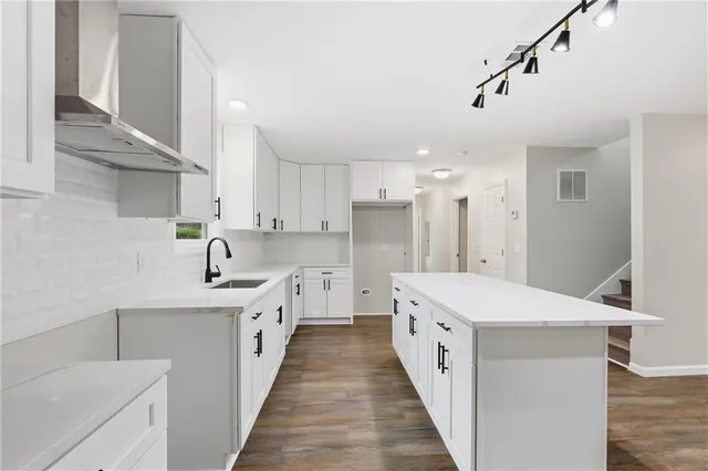 a large white kitchen with a white stove a sink and dishwasher