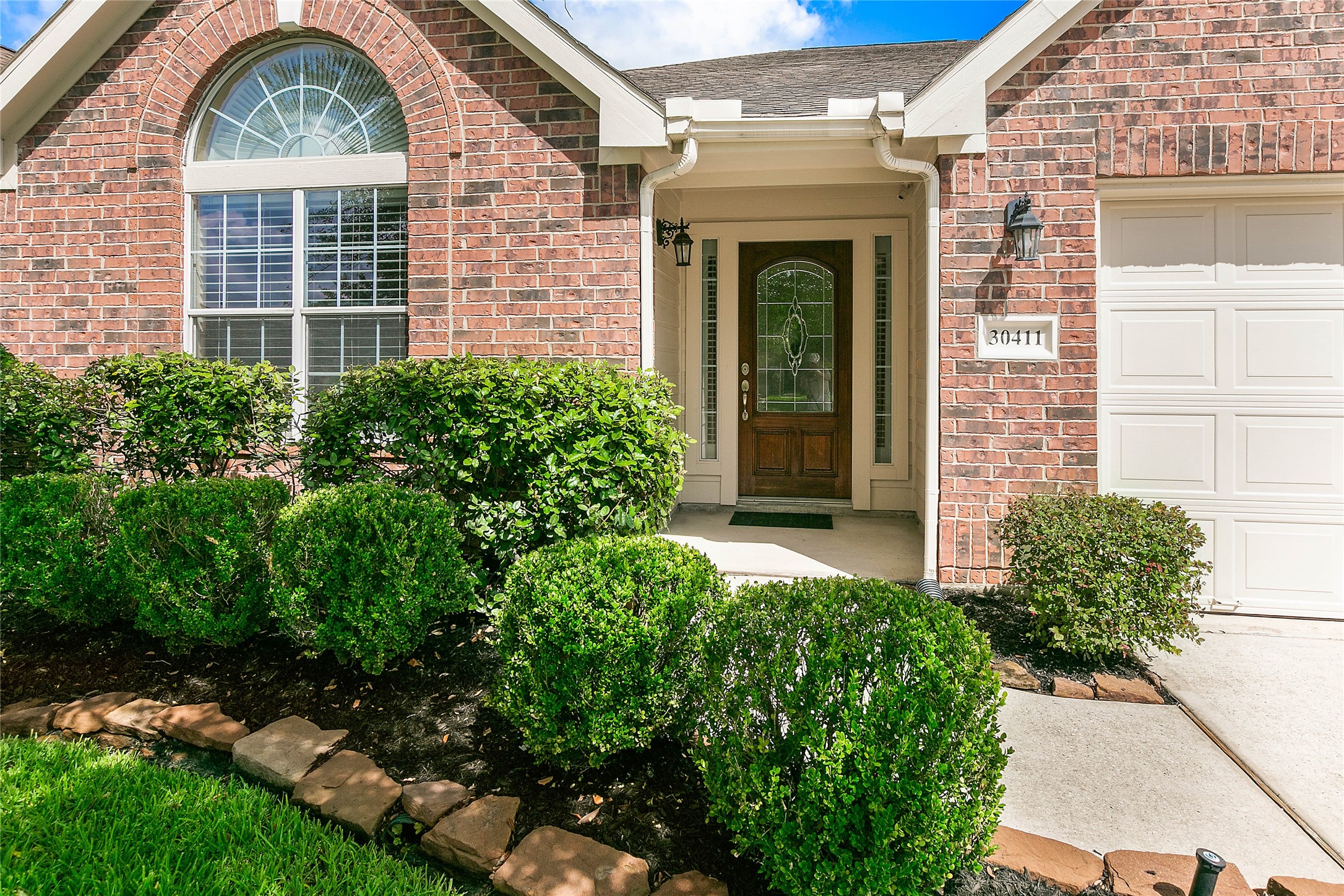 30411 Deleon Fields Drive Spring, TX 77386 - Photo 2 of 24 Discover refined details at the front entry, framed by manicured shrubs.