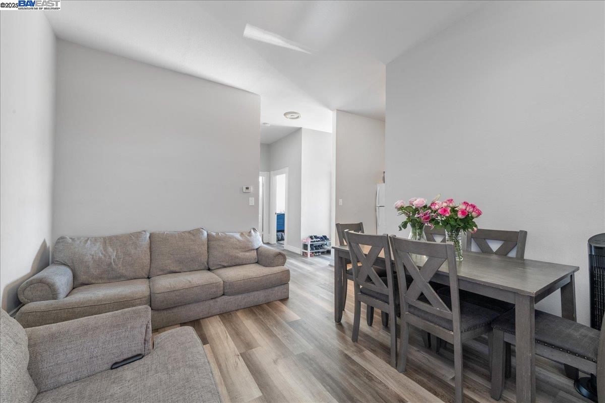 3214 13th Avenue Oakland, CA 94610 - Photo 16 of 51 a living room with furniture and a dining table with wooden floor