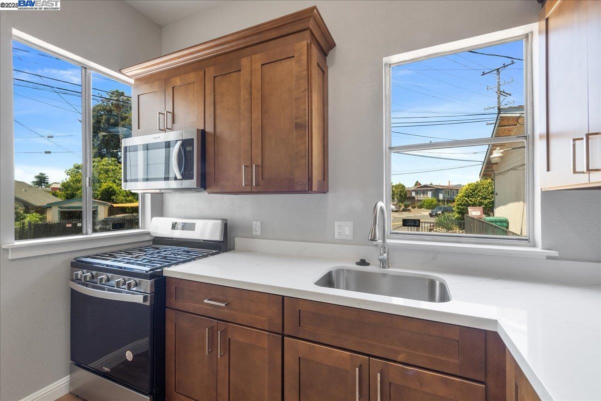 3214 13th Avenue Oakland, CA 94610 - Photo 9 of 51 a kitchen with stainless steel appliances granite countertop a sink stove and cabinets