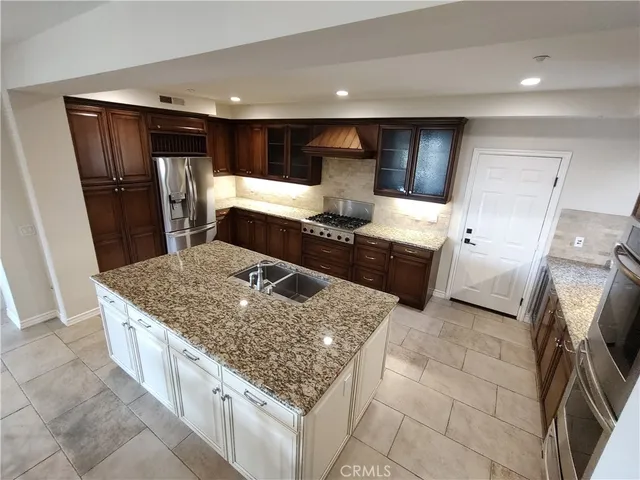 a kitchen with stainless steel appliances granite countertop a sink stove and refrigerator