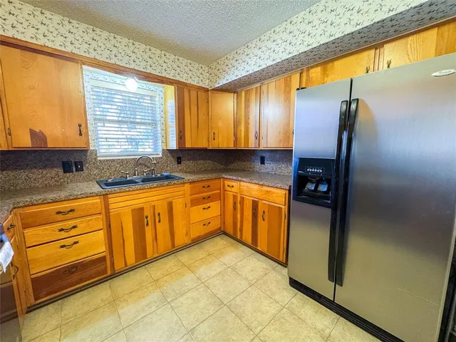 a kitchen with granite countertop a stove top oven microwave and cabinets