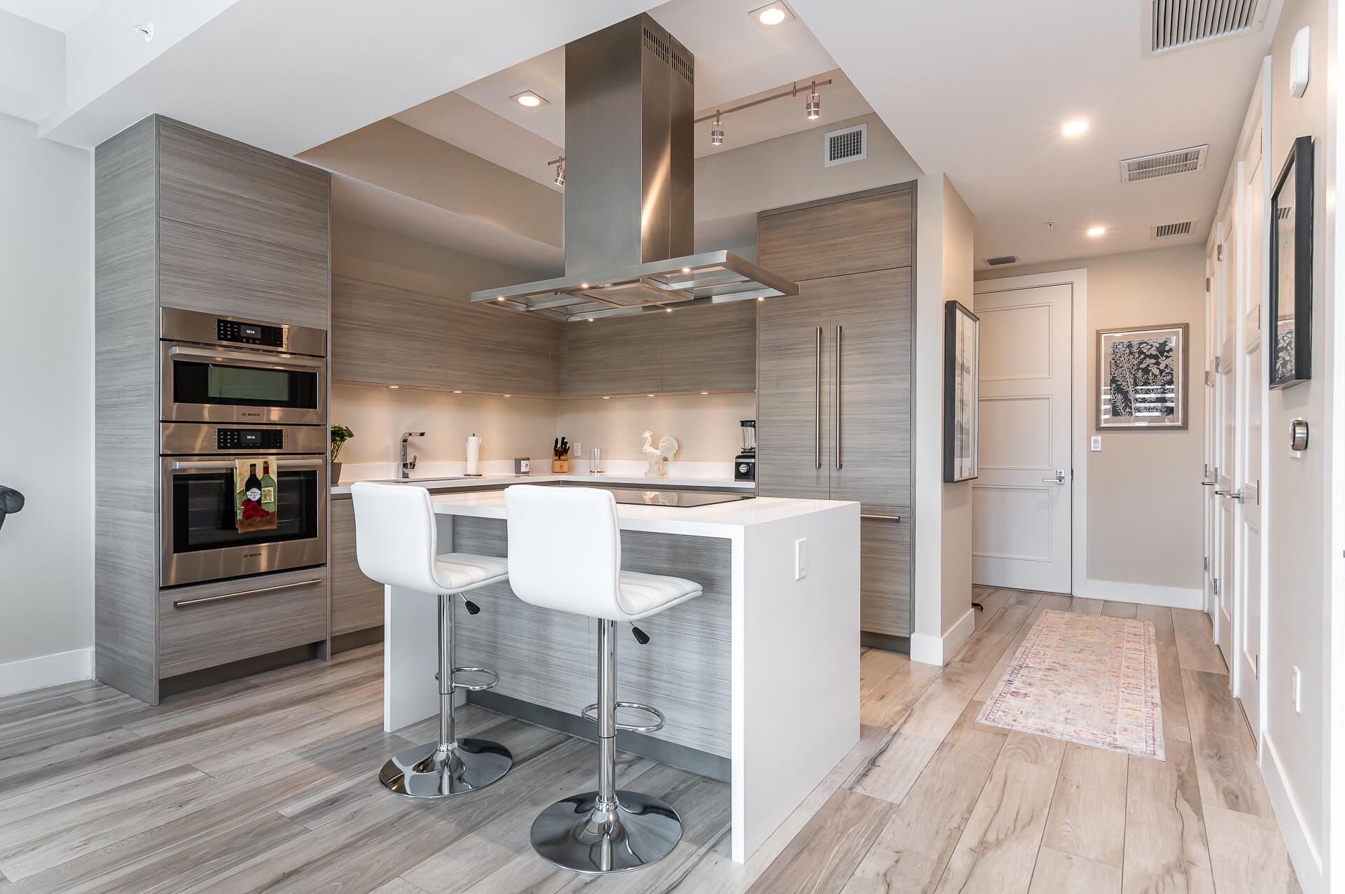 155 East Boca Raton Road, Unit 1012 Boca Raton, FL 33432 - Photo 3 of 41 a kitchen with kitchen island stainless steel appliances a table chairs refrigerator and cabinets