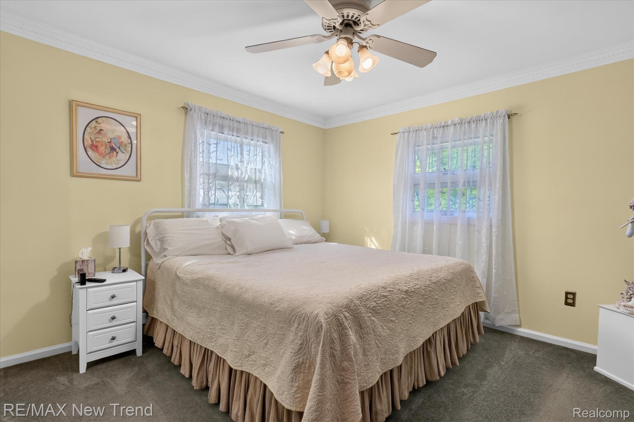 2529 South Commerce Road Walled Lake, MI 48390 - Photo 28 of 66 Ceiling fan with integrated lighting, crown molding, two windows with decorative trim, and wall-to-wall carpeting