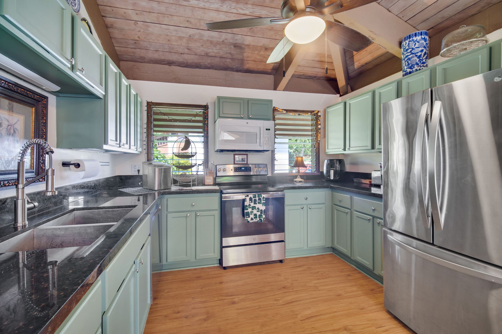 4701 Kawaihau Road, Unit F201 Kapaa, HI 96746 - Photo 8 of 24 a kitchen with stainless steel appliances granite countertop a sink a stove a refrigerator and cabinets
