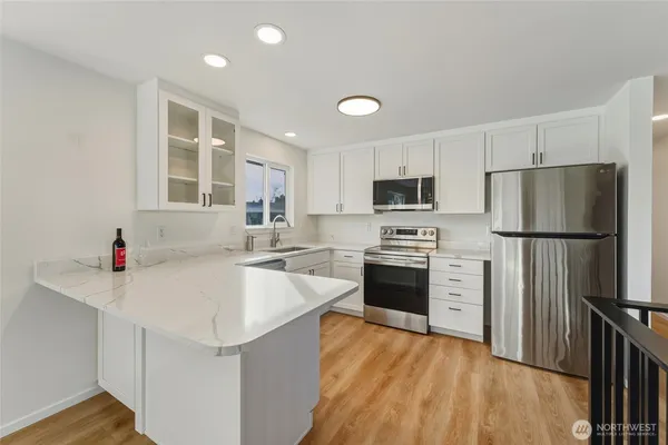 a kitchen with granite countertop a refrigerator stove top oven and sink