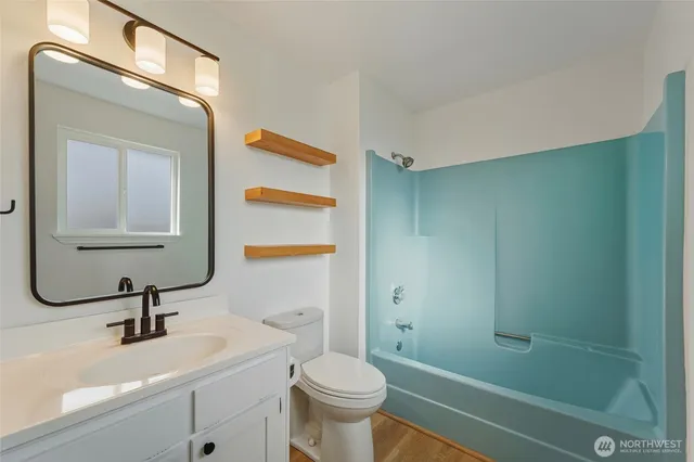 a bathroom with a sink a toilet and a mirror
