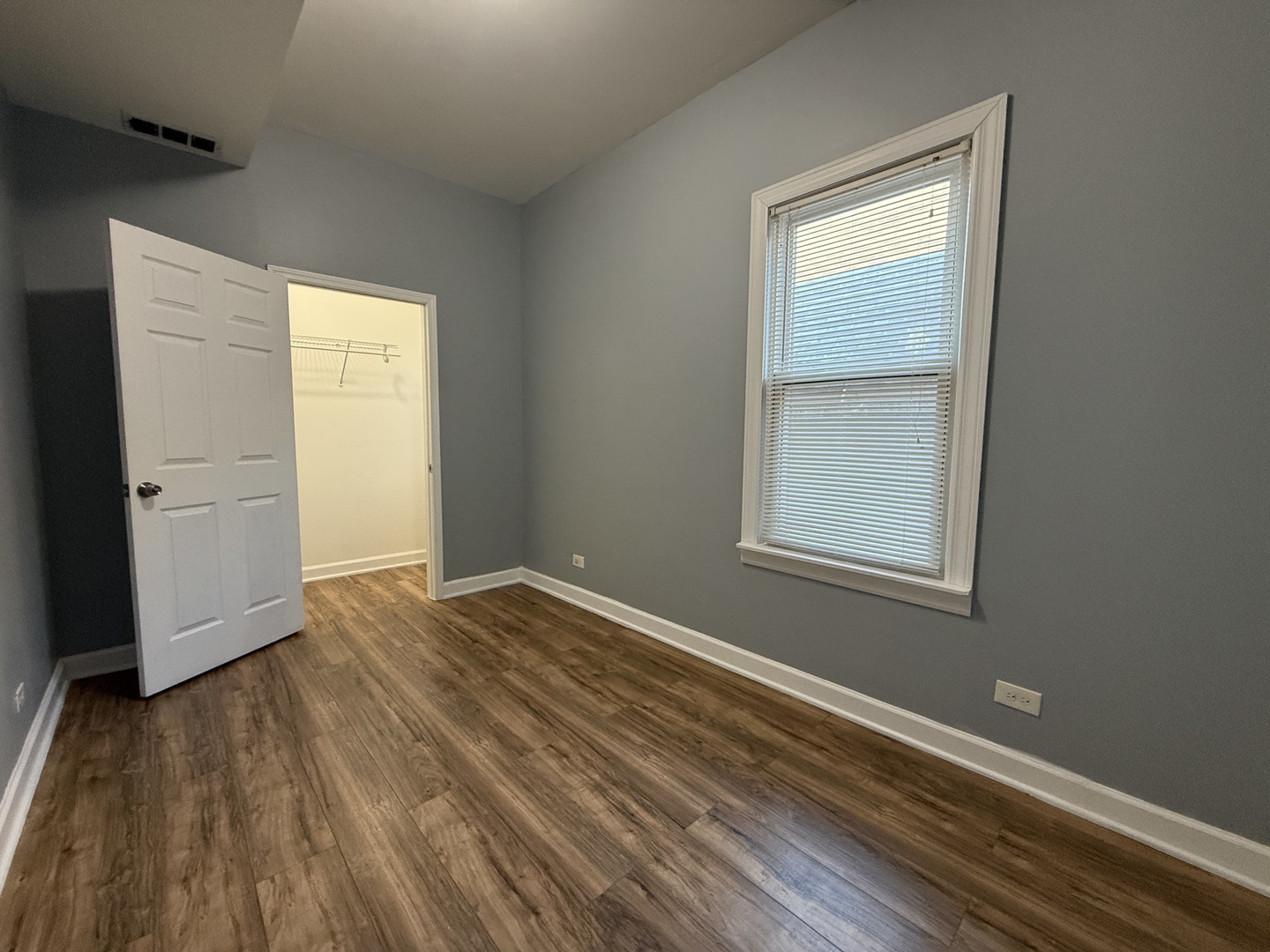 9738 South Ave L, Unit 2 Chicago, IL 60617 - Photo 4 of 11 an empty room with wooden floor closet and windows