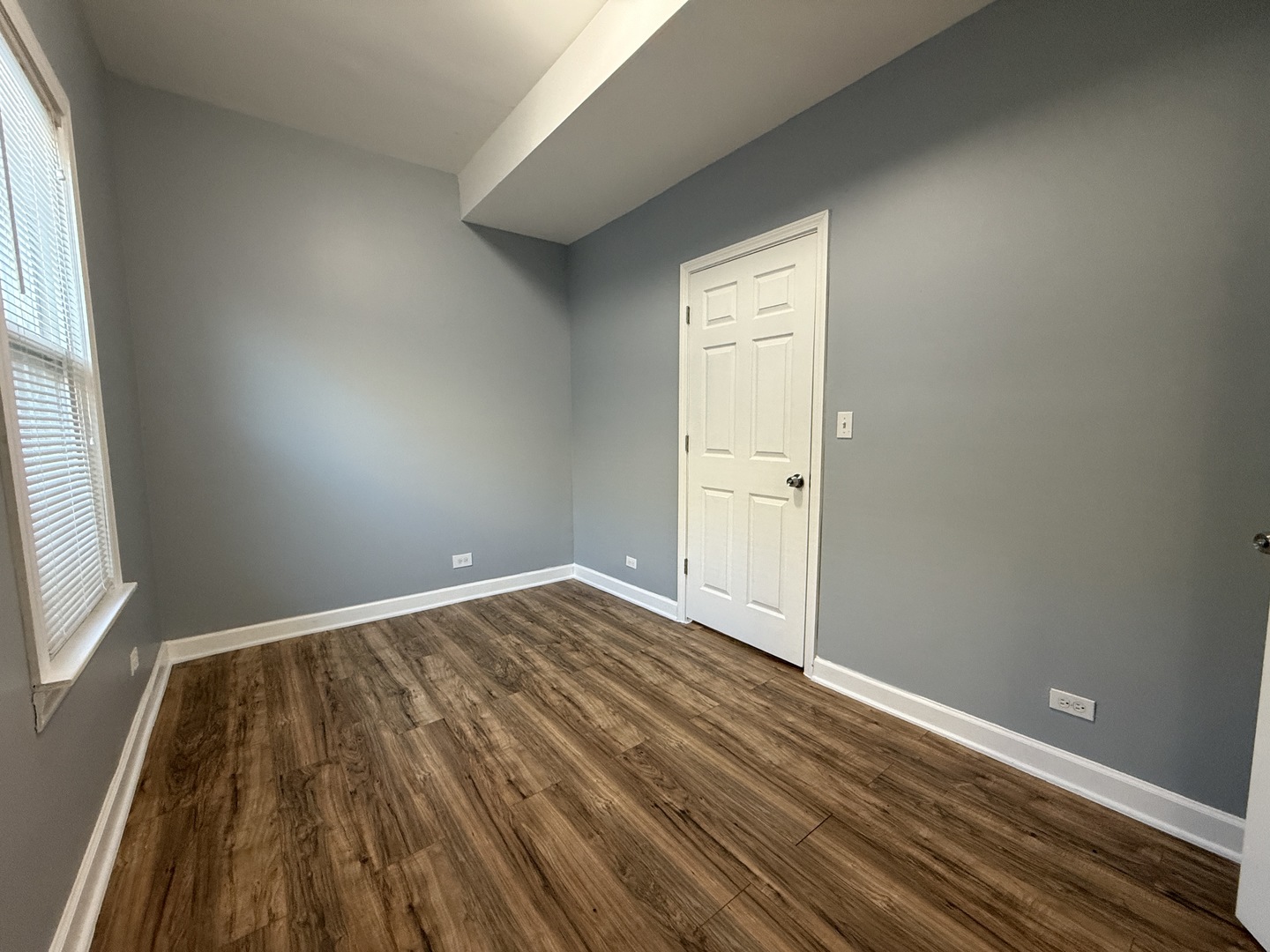 9738 South Ave L, Unit 2 Chicago, IL 60617 - Photo 5 of 11 an empty room with wooden floor and windows